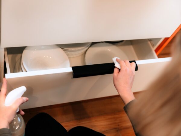 Cleaning the handles on the kitchen drawer with Figgy & Co's Everyday Spray