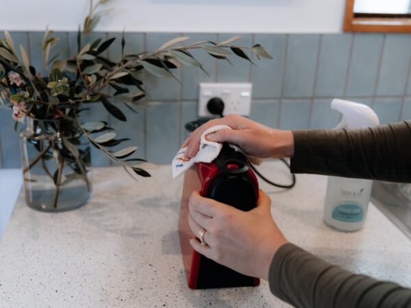 Cleaning the exterior of a coffee machine with Figgy & Co Everyday Spray