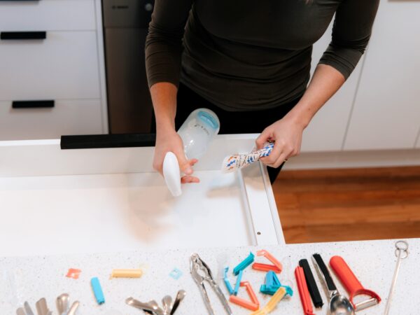 Spraying kitchen drawer with Figgy & Co's Everyday Spray